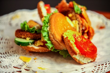 Hamburger fast food with ham on wooden board on lacy napkin. Group of hamburger.の写真素材