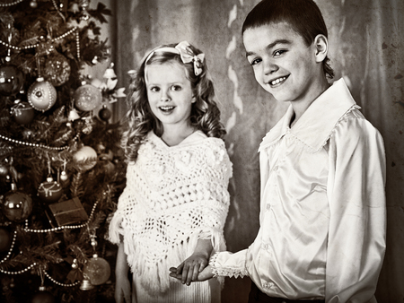 Black and white picture children under Christmas tree. Christmas retro style. Old picture. Brother...