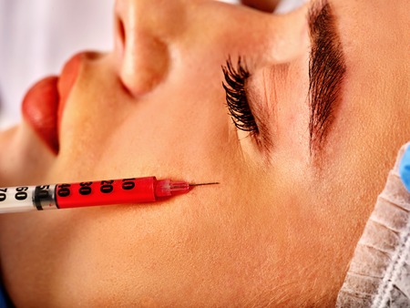 Filler injection for female forehead face. Plastic aesthetic facial surgery in beauty clinic. Beauty...