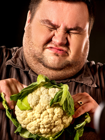 Diet fat man eating healthy food. Healthy breakfast with vegetables cauliflower. Male trying to lose...
