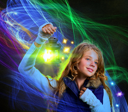 Lantern light with candle lamp in woman hand into winter magic night on moving flames lines.の写真素材