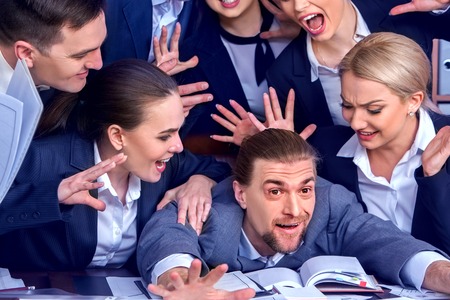 Business people office. Team people are unhappy with their leader. Intern man manager does not cope with his duties. Crowd in stress throw up their chiefs papers. Photosession memory.の写真素材