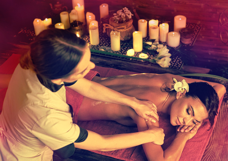 Massage and aromatherapy of woman getting rid of cramps in spa candle salon with healer.の写真素材