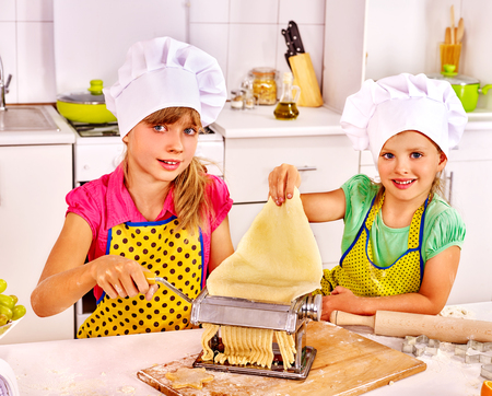 Two children girl making homemade pasta at kitchen.の写真素材