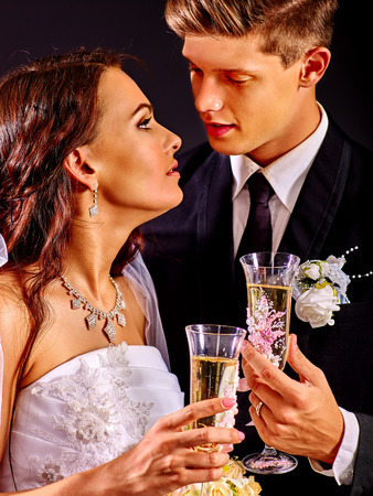 Wedding couple kissing and drinking bubbly.の写真素材