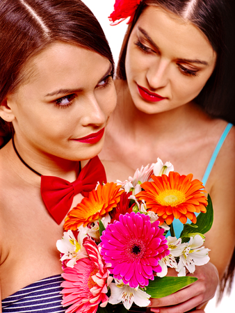 Two sexy lesbian women holding flower bouquet. Isolated.の写真素材