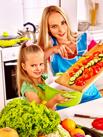 Mother and daughter cooking vegetable soup  at kitchen.の写真素材