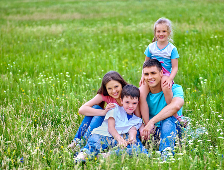 Happy family  with two children on green grass. Outdoor.の写真素材
