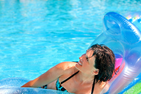 Happy woman  swimming on inflatable beach mattress. Looking up.の写真素材