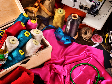 Sew seamstress group object sewing spool and embroidery hoop in wooden box on coat fabric.の写真素材