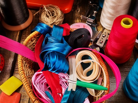 Sewing accessories coil threads and bias tape in basket supplies close up.の写真素材