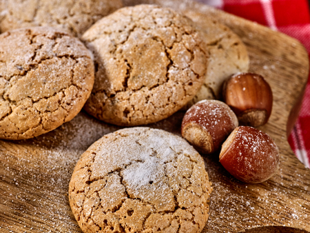 Oatmeal cookies and nut cookies with crack pattern on cutting board on table in rustic style. Hazelnuts in the peel.の写真素材