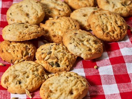 Oatmeal cookies with husk unpeeled oats on kitchen gingham checkered cotton fabric on table in farm-style.の写真素材