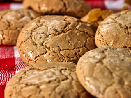 Oatmeal cookies with crack pattern on red kitchen gingham checkered cotton fabric on table in farm-style.の写真素材