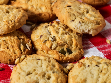 Oatmeal cookies with husk whole oats on red kitchen gingham checkered cotton fabric on table in farm-style.の写真素材