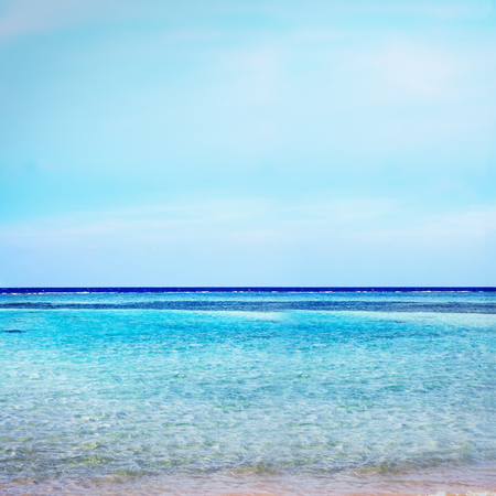 Beach on crystal with azure ocean and blue sky horizon background.の写真素材