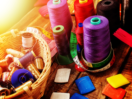 Sewing accessories fabric crayons, coil threads and measuring tape in basket supplies close up.の写真素材