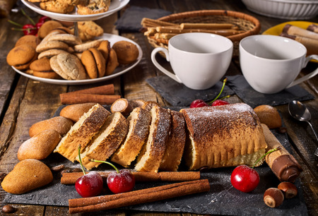 Oatmeal and nut cookies heart shape and sand rolled biscuit on tier cake stand and cinnamon stick on kitchen on wood table in rustic style. Easily digestible and quickly digestible substances.の写真素材