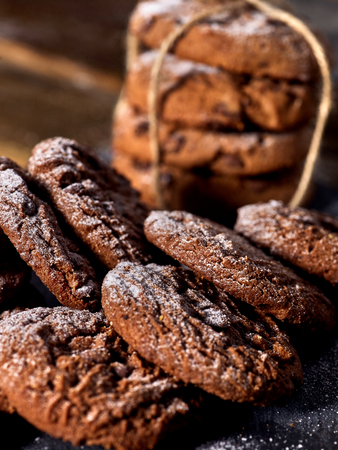 Serving food on slate onto wooden table. Oatmeal cookies biscuit with blueberry on picnic dark tiles countrylike. Chocolate chip cookies tied with string. Serve this dish hot.の写真素材