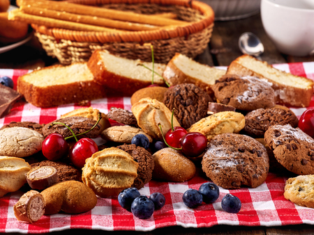 Cookies and sand biscuit on tier cake stand with blueberry chocolate on kitchen on picnic table in rustic natural style. Serve this dish hot.の写真素材
