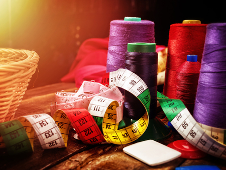 Serger or overlock thread in seamstress with group sew object sewing spool on morning sunrise light sun flare. Exhibition of accessories. Every season the range is always updated.の写真素材