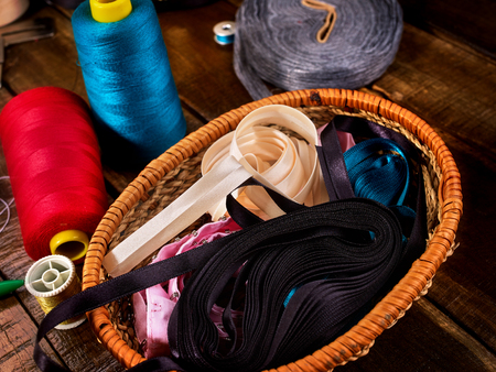 Sewing accessories coil threads and measuring tape in basket supplies close up. Every season range is always updated. Sales growth in clothing industry.の写真素材