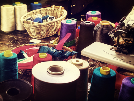 Coil threads for overlock and measuring tape in sewing supplies in on morning sunrise light sun flare. Sewing accessories helps to make our clothes fashionable.の写真素材