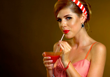 Girl drinks martini cocktail. Woman on thematic party retro old fashioned style. New, unique cocktail recipes.の写真素材