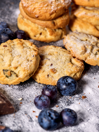 Serving food on slate onto wooden table. Oatmeal cookies biscuit with blueberry on picnic dark tiles countrylike. Chocolate Xmas holiday chip cookies tied with string. Perfect product High fat contentの写真素材