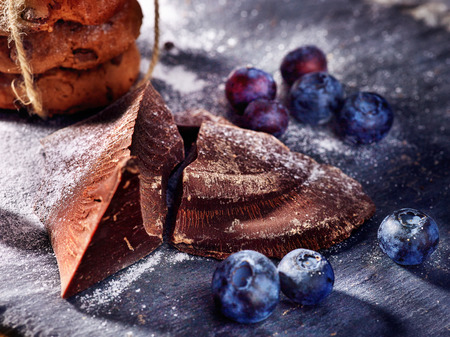 Serving food on slate onto wooden table. Oatmeal cookies biscuit with blueberry on picnic dark tiles countrylike. Chocolate Xmas holiday chip cookies. Best range of confectionery products.の写真素材