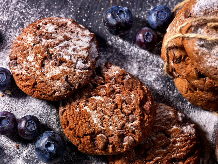 Serving food on slate onto wooden table. Oatmeal cookies biscuit with blueberry on picnic. Chocolate Xmas holiday chip cookies tied with string. Perfect product. Lunch in inexpensive cafe.の写真素材