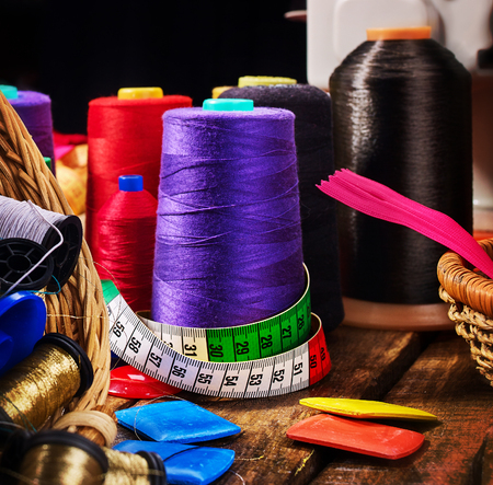 Coil threads for overlock and measuring tape with zipper in sewing supplies close up. Sewing accessories helps to make our clothes fashionable.の写真素材