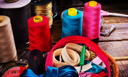Sewing accessories coil threads and measuring tape in basket supplies close up. Sewing quality clothing to order.の写真素材