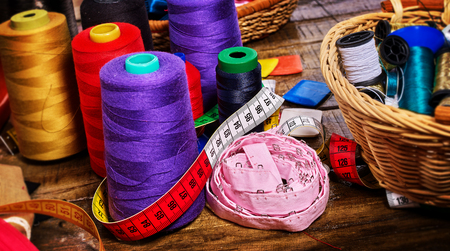 Sewing accessories coil threads and measuring tape in basket supplies close up. Every season range is always updated. Masters of cutting and sewing.の写真素材