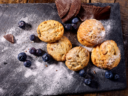 Serving food on slate onto wooden table. Oatmeal cookies biscuit with blueberry on picnic. Chocolate Xmas holiday chip cookies tied with string. Perfect product. Delightful, unique taste.の写真素材