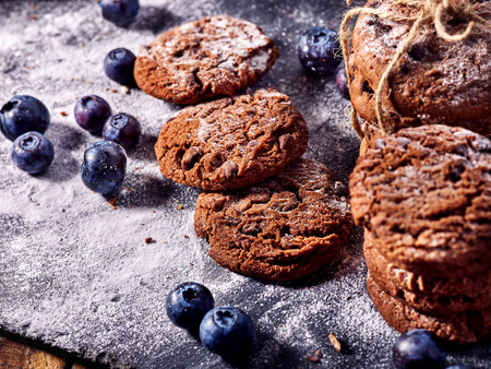 Serving food on slate onto wooden table. Oatmeal cookies biscuit with blueberry on picnic. Chocolate Xmas holiday chip cookies tied with string. Perfect product. Composition of confectionery.の写真素材