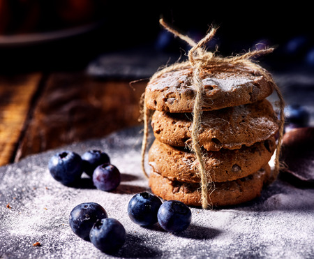 Bakers gonna bake. Serving food on slate. Oatmeal cookies biscuit with blueberry on dark tiles countrylike. Chocolate chip cookies tied with string shop on window display Stories of appearance of foodの写真素材