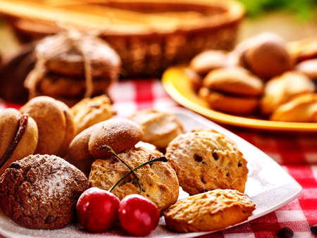 Oatmeal Cookies and sand chocolate cake on gingham napkin in farm style close up. Table setting breakfast .の写真素材