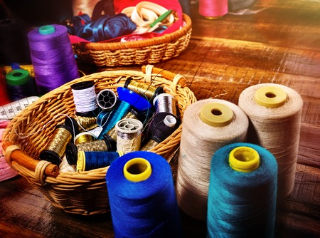 Sewing accessories coil threads and measuring tape in basket supplies close up. Learning to sew at home.の写真素材