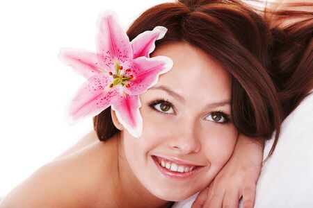 Girl with flower in hair on massge in spa salon isolated.の写真素材