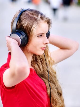 Student girl in headphone listen music after exam. Time to relaxin street city. Walk helps get rid of stress.の写真素材