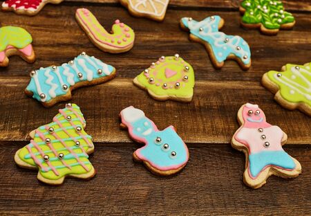Decorative Christmas cookies background on wooden board. Close up of ginger biscuits Xmas tree and gingerbread man with icing on horizontal frame.の写真素材