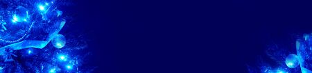 Christmas background horizontal long frame. Part of blue Xmas tree and copy space banner with left bottom corner.の写真素材