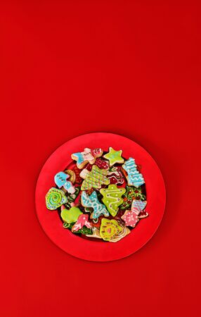 Christmas gingerbread cookies on red Xmas plate and same color background . Top view long vertical design frame with copy space top.の写真素材