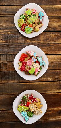 Christmas gingerbread cookies on three plates by wooden table . Top view long vertical banner design frame.の写真素材