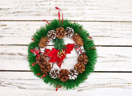 Christmas wreath decoration hangs on front door who made from white wooden boards.の写真素材