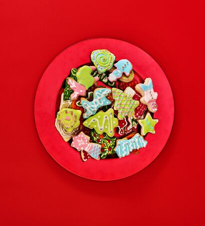 Christmas gingerbread cookies on red Xmas plate and same color background . Top view long vertical design frame with copy space top.の写真素材