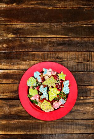 Christmas gingerbread cookies on red Xmas plate and wooden boards background . Top view long vertical design frame with copy space top.の写真素材