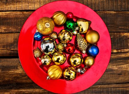 Christmas decorations design top view of Xmas balls ornaments on red plate on wooden boards .の写真素材