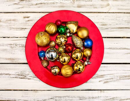 Christmas decorations design top view of Xmas balls ornaments on red plate onto horizontal white wooden boards .の写真素材
